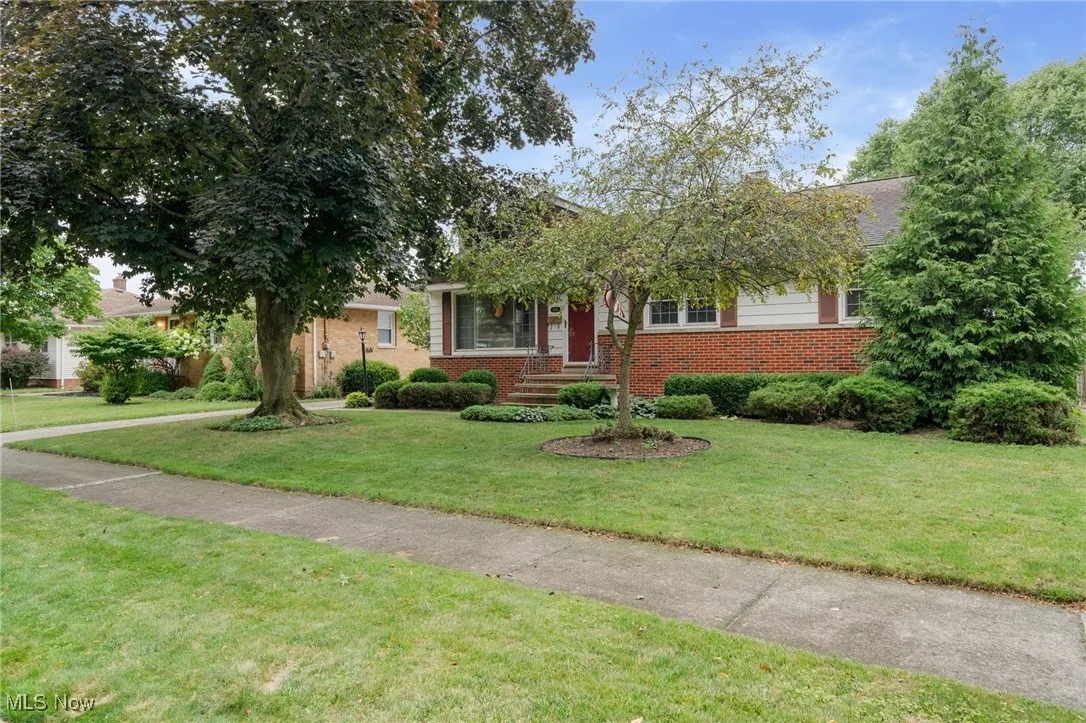 View of front of property featuring brick siding and a front lawn