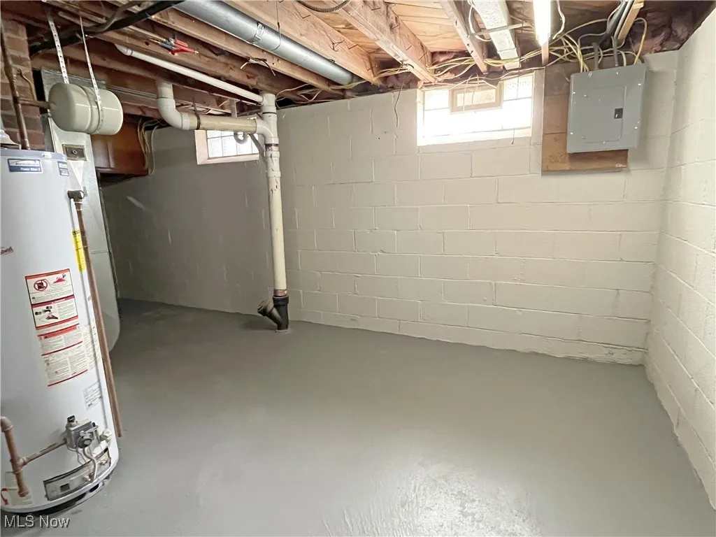 Basement with water heater and electric panel