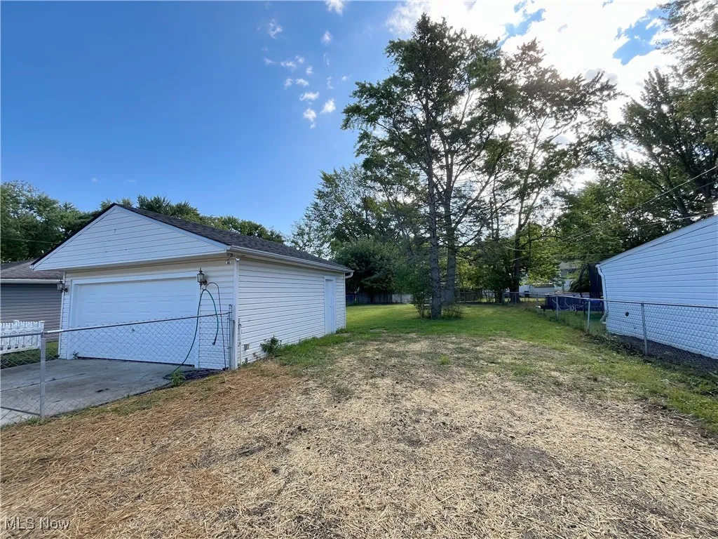 View of yard with an outdoor structure and a garage