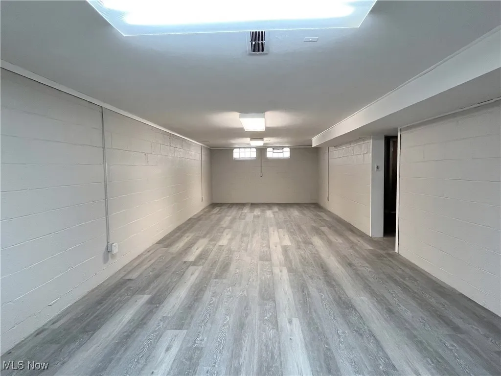 Below grade area featuring wood finished floors and concrete block wall