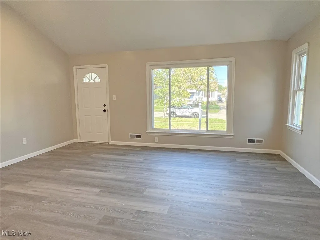 Foyer with light wood-style floors and lofted ceiling