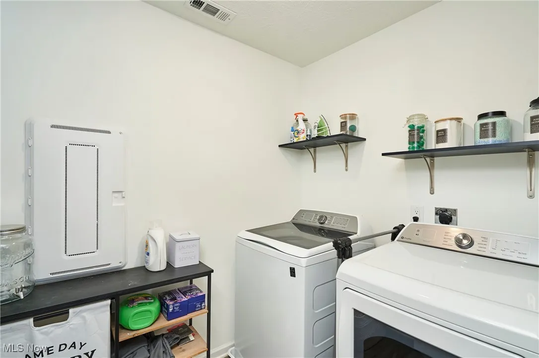 Laundry room with washer and clothes dryer and electric panel