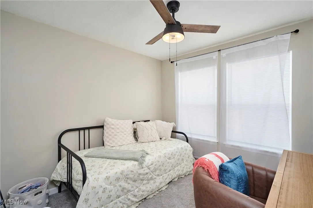 Carpeted bedroom featuring ceiling fan