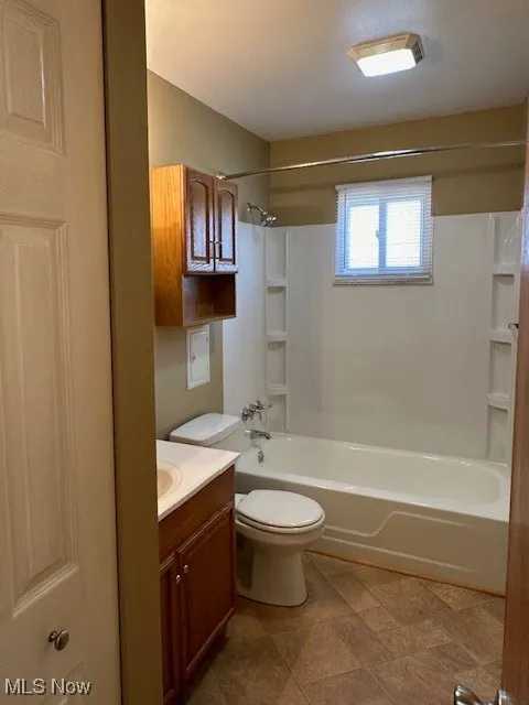Full bathroom with toilet, vanity, and tub / shower combination