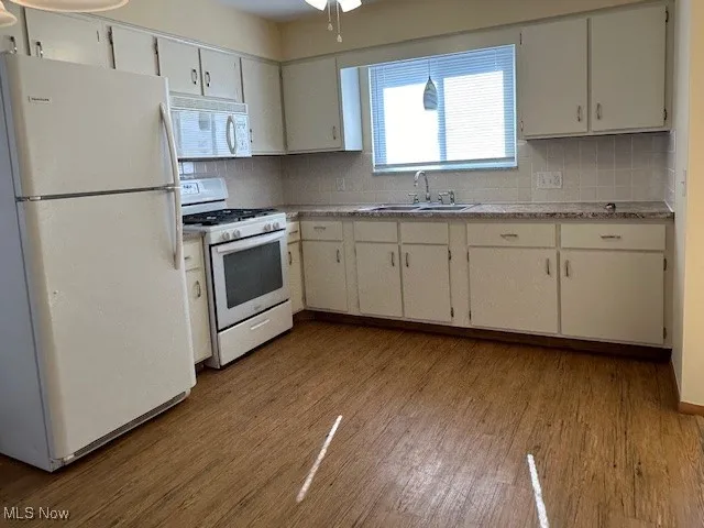 Kitchen with refrigerator, range, sink, and light wood-type flooring