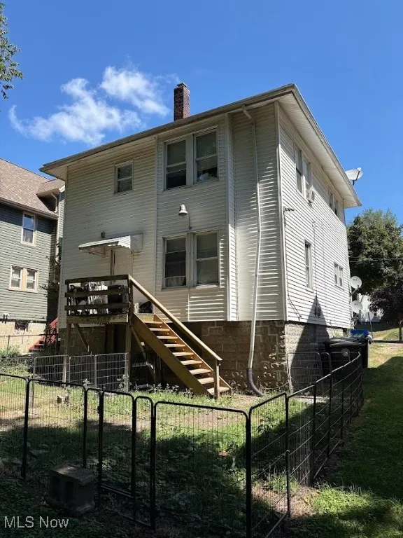 Back of property with stairs and a chimney
