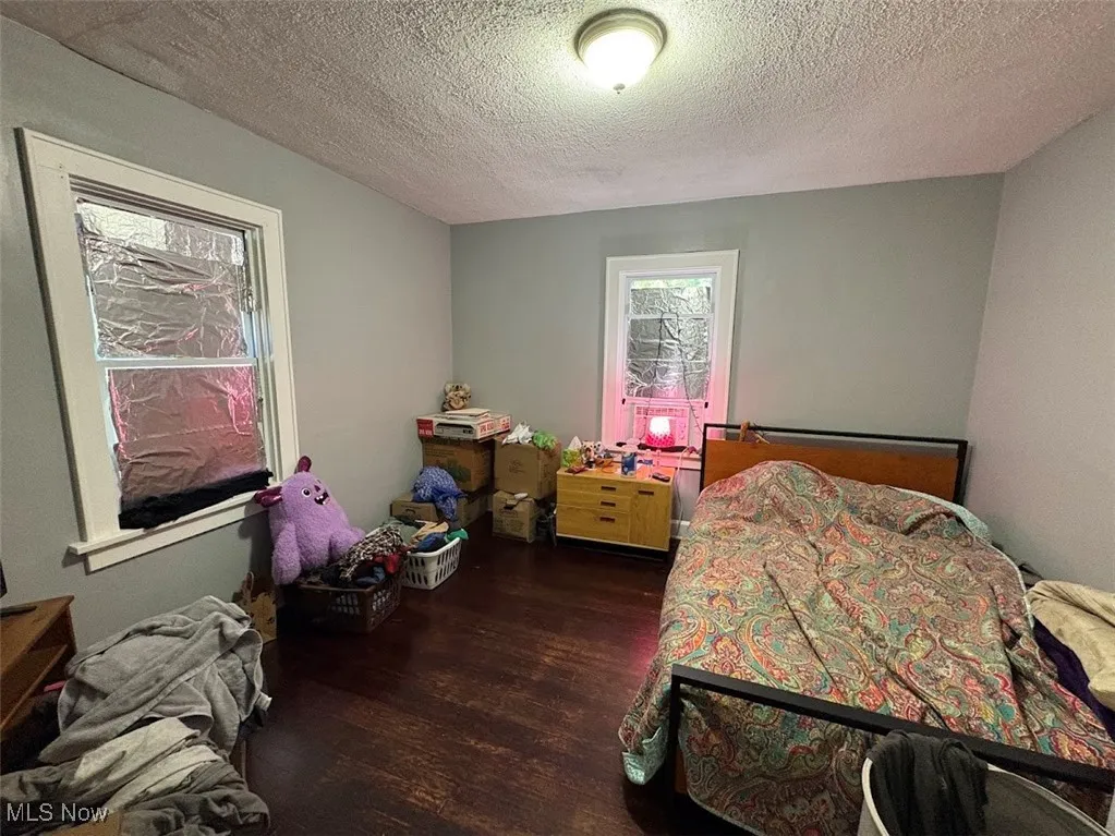 Bedroom featuring a textured ceiling and dark wood-style floors