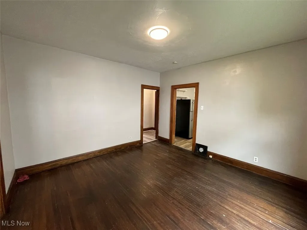 Empty room with baseboards and dark wood finished floors