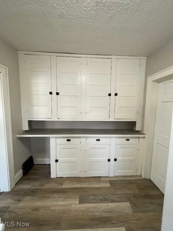 Detailed view of wood finished floors and a textured ceiling