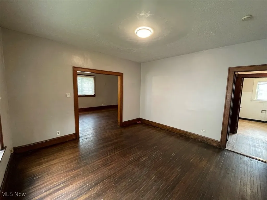 Spare room featuring dark wood-style flooring and a textured ceiling