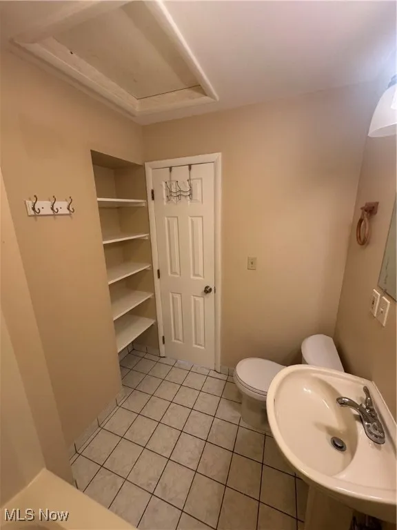 Bathroom with light tile patterned flooring and toilet