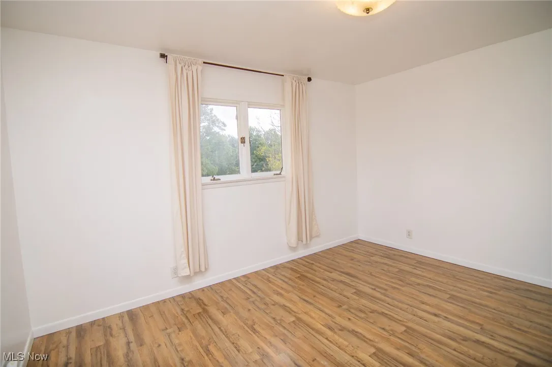 Empty room with wood finished floors and baseboards