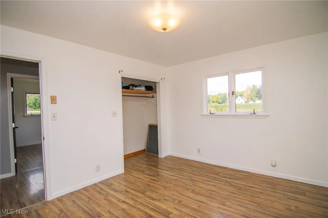 Unfurnished bedroom with wood finished floors and a closet