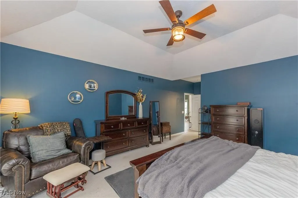 Bedroom featuring carpet, a ceiling fan, and vaulted ceiling
