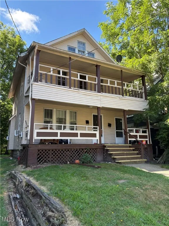 View of front facade with covered porch and a front lawn