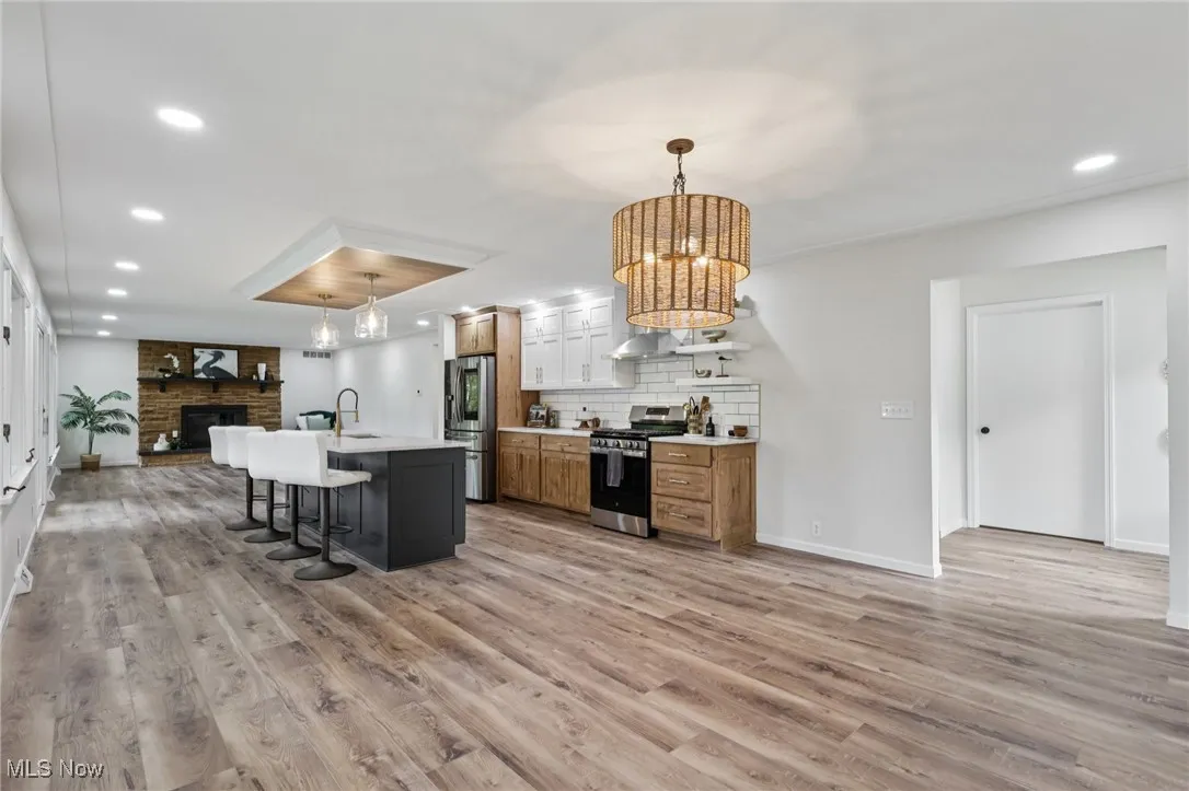 Kitchen featuring open floor plan, recessed lighting, a breakfast bar, hanging light fixtures, and appliances with stainless steel finishes