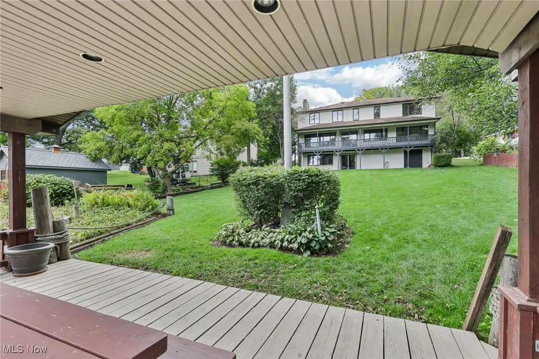 View of grassy yard featuring a wooden deck