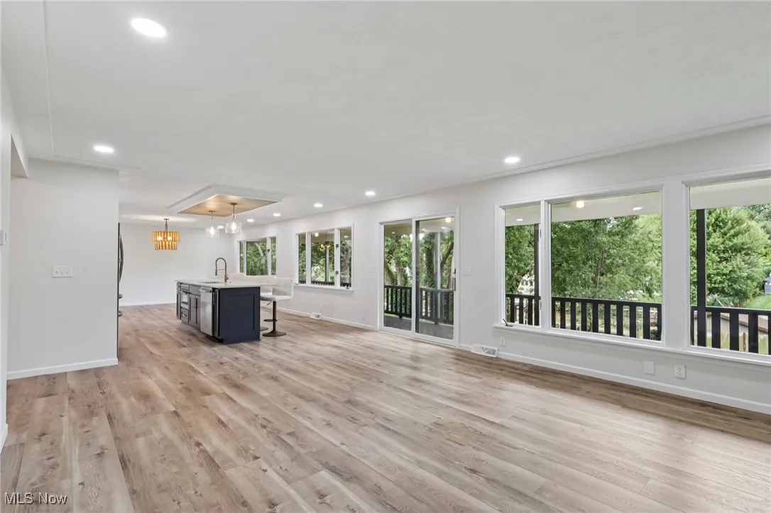 Unfurnished living room with light wood-style floors, plenty of natural light, and recessed lighting