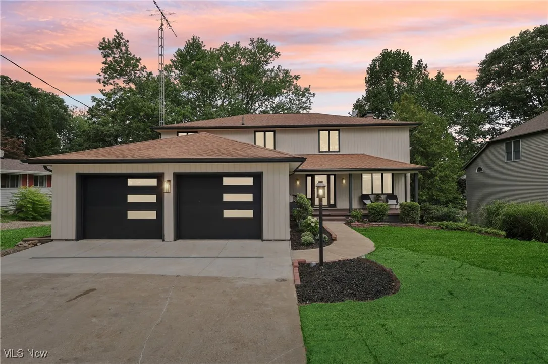 Prairie-style home with a garage, a shingled roof, a front yard, driveway, and covered porch