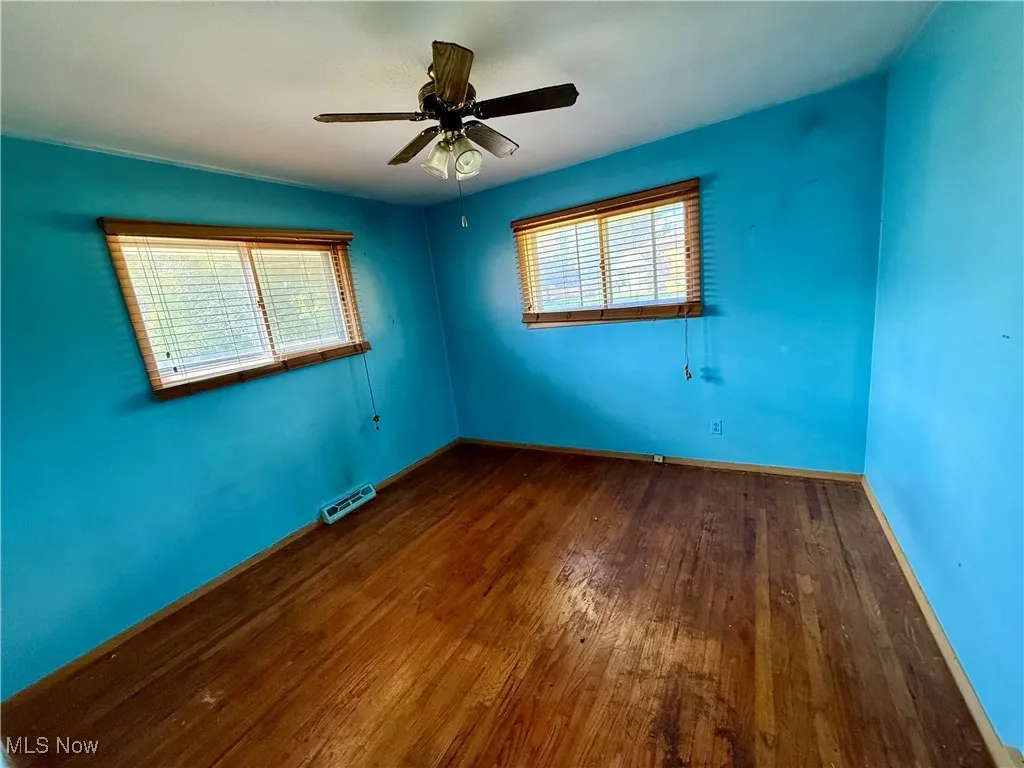 Empty room featuring wood finished floors and a ceiling fan