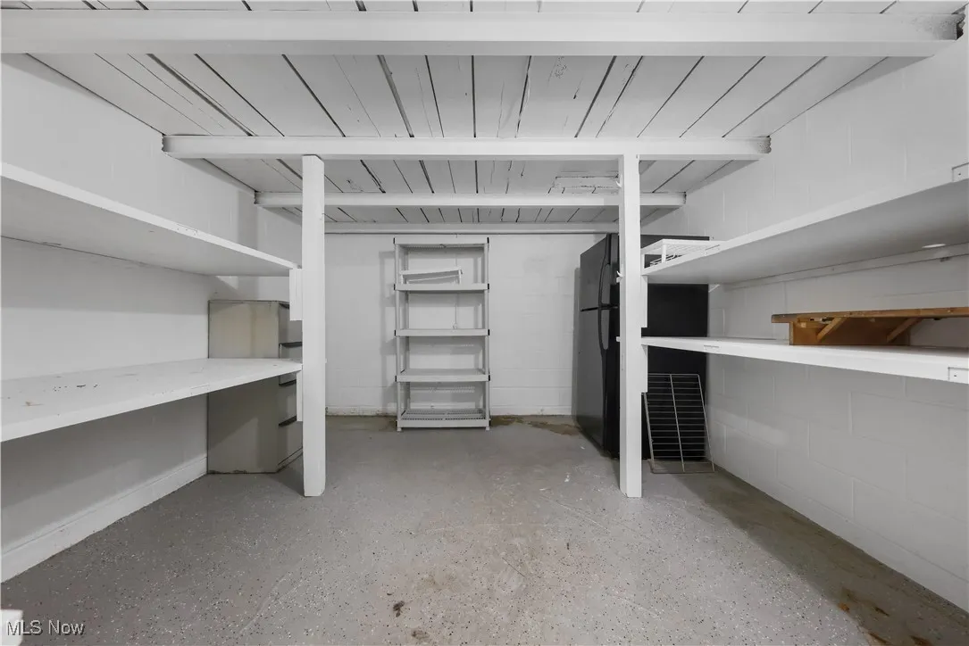 Storage room off the utility room including a 2nd refrigerator and shelving.