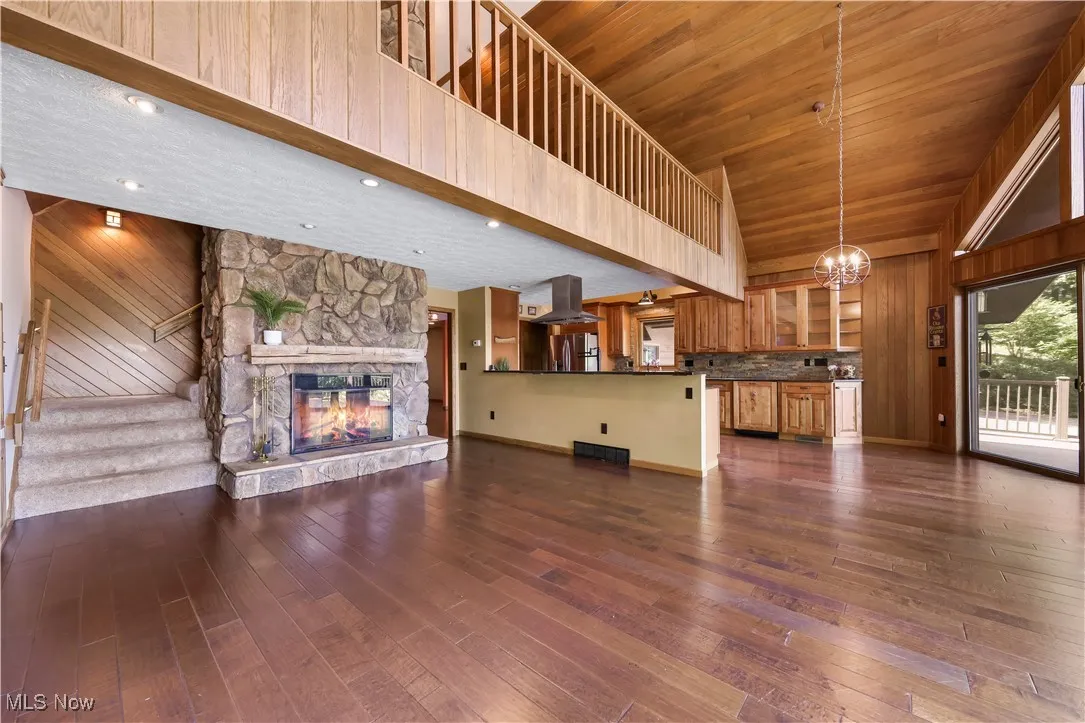 Dining room with views of the loft, open floor plan, floor-to-ceiling stone fireplace opening into the kitchen