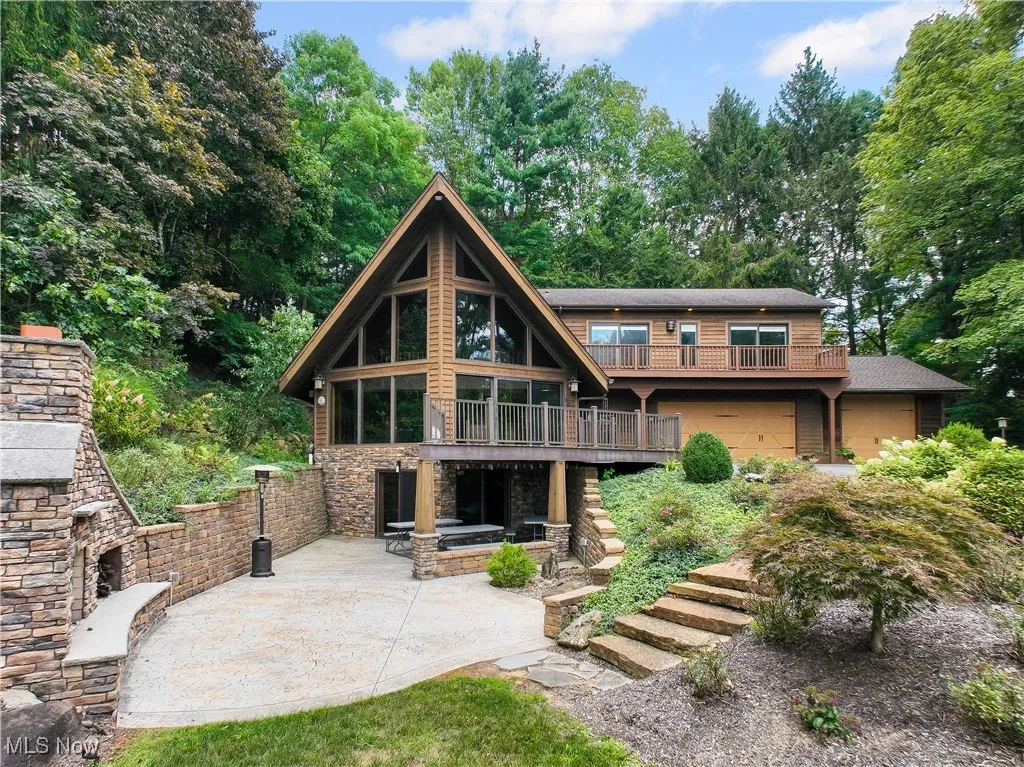 Former Akron Ski Club converted to a contemporary home including a deck, stairs, stone fireplace and patio on the LL