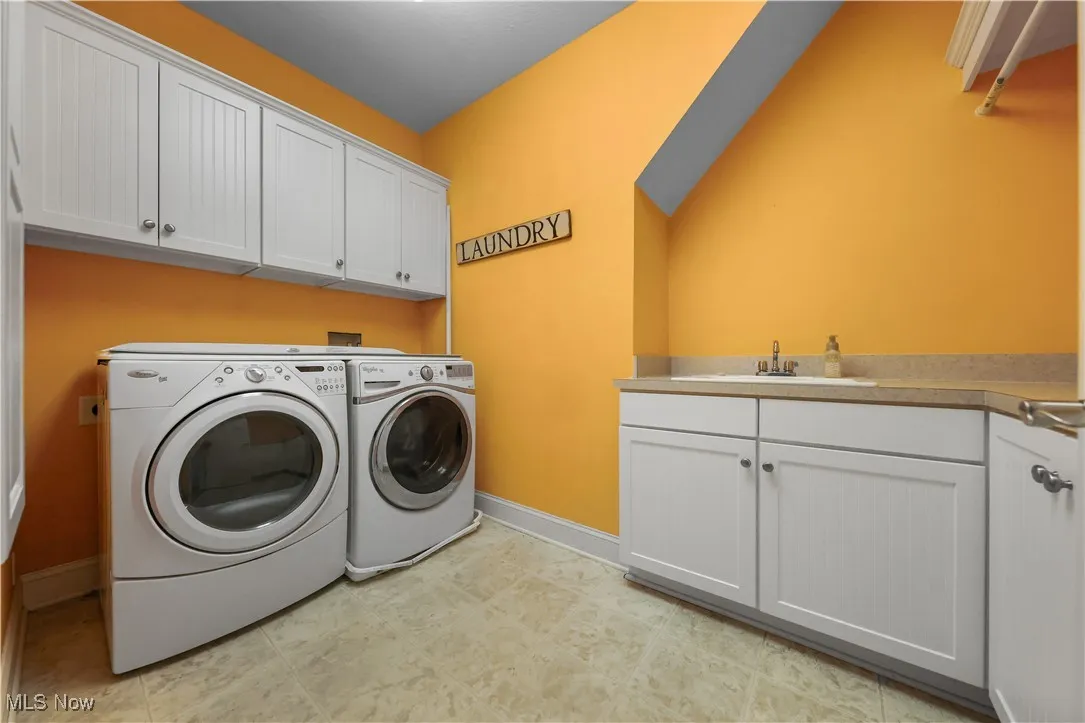 Laundry area featuring cabinets, sink, washer and dryer