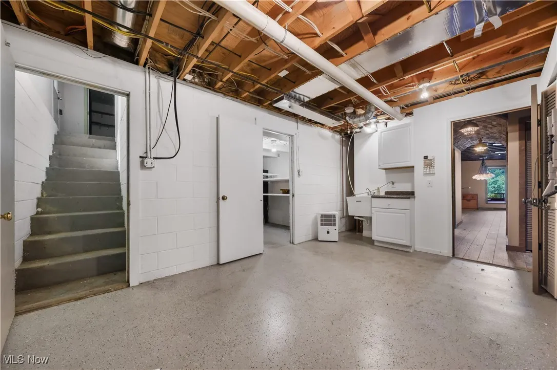 Utility room with many storage closets including a walk-in storage room and stair access to the garage.