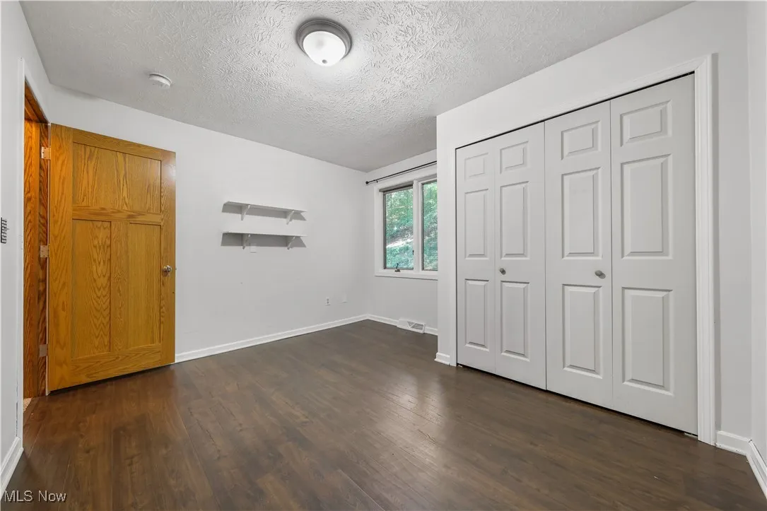 Guest bedroom featuring wood flooring and a closet