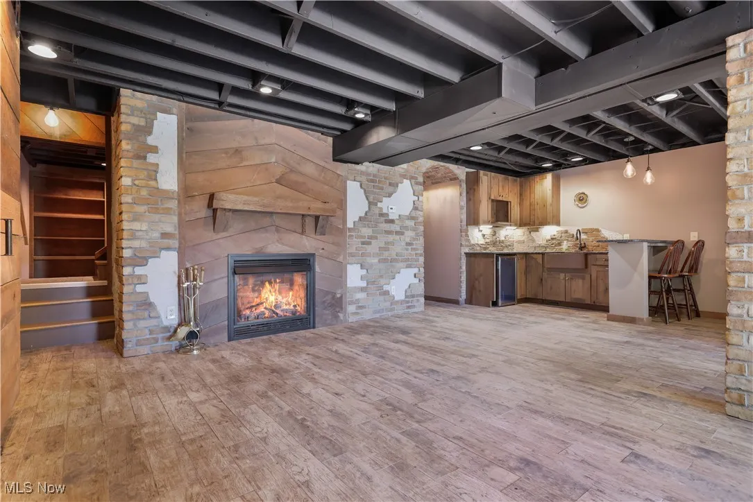LL recreation room with a fireplace and brick that adds character.
