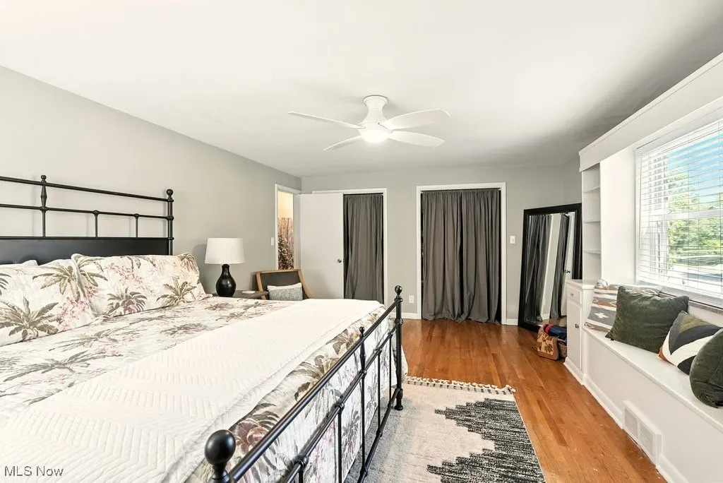 Bedroom featuring light wood-style floors, multiple closets, and ceiling fan