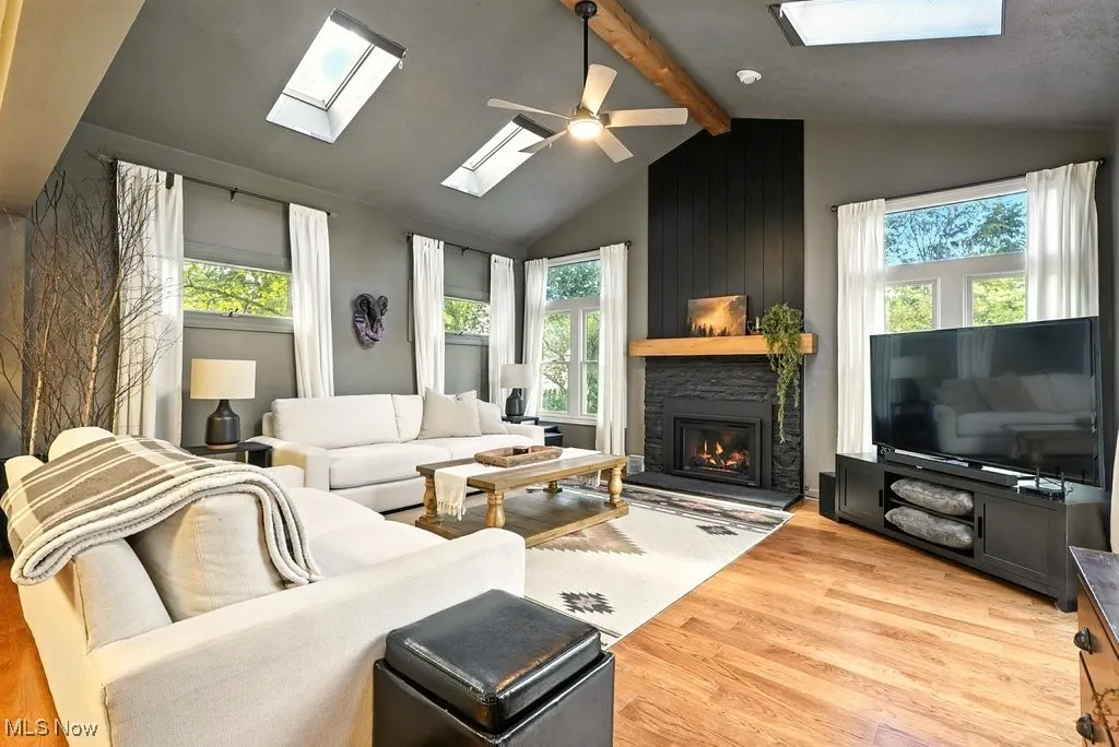 Living area with plenty of natural light, light wood-type flooring, and a skylight