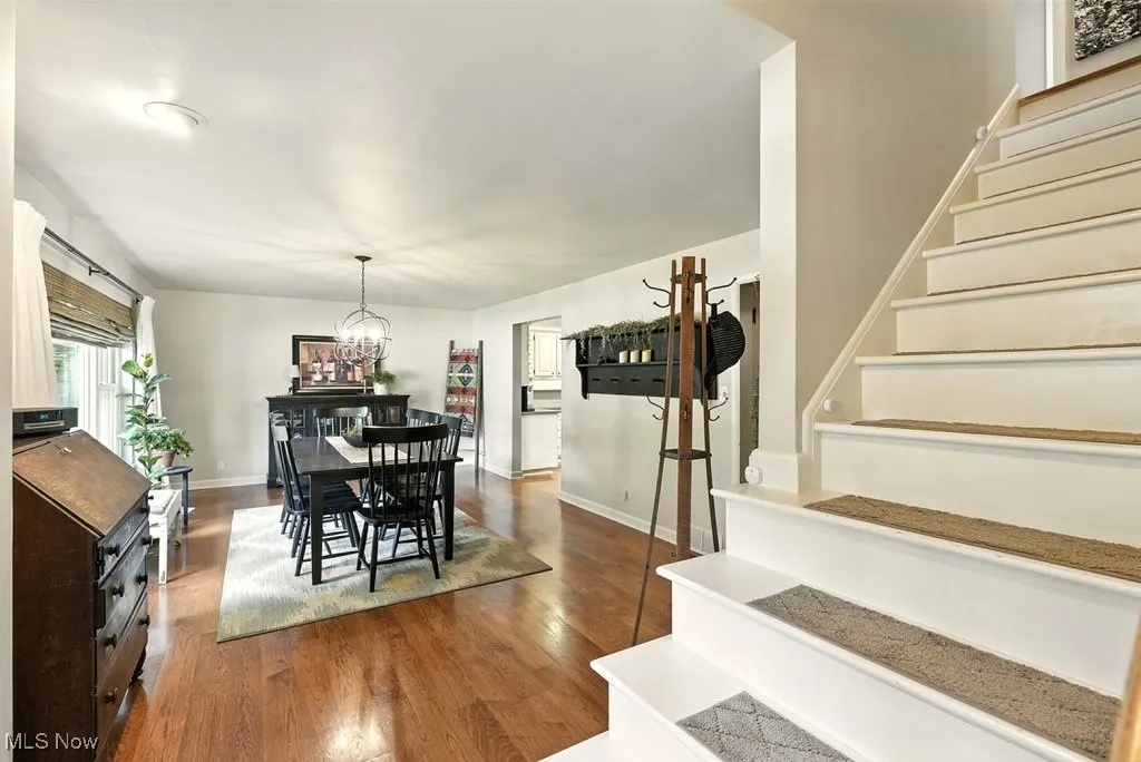 Dining space featuring stairs, wood finished floors, and a chandelier