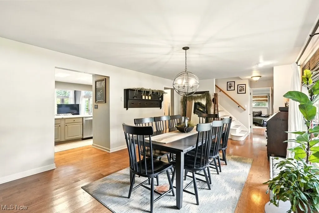 Dining area featuring healthy amount of natural light, light wood-style floors, and stairway