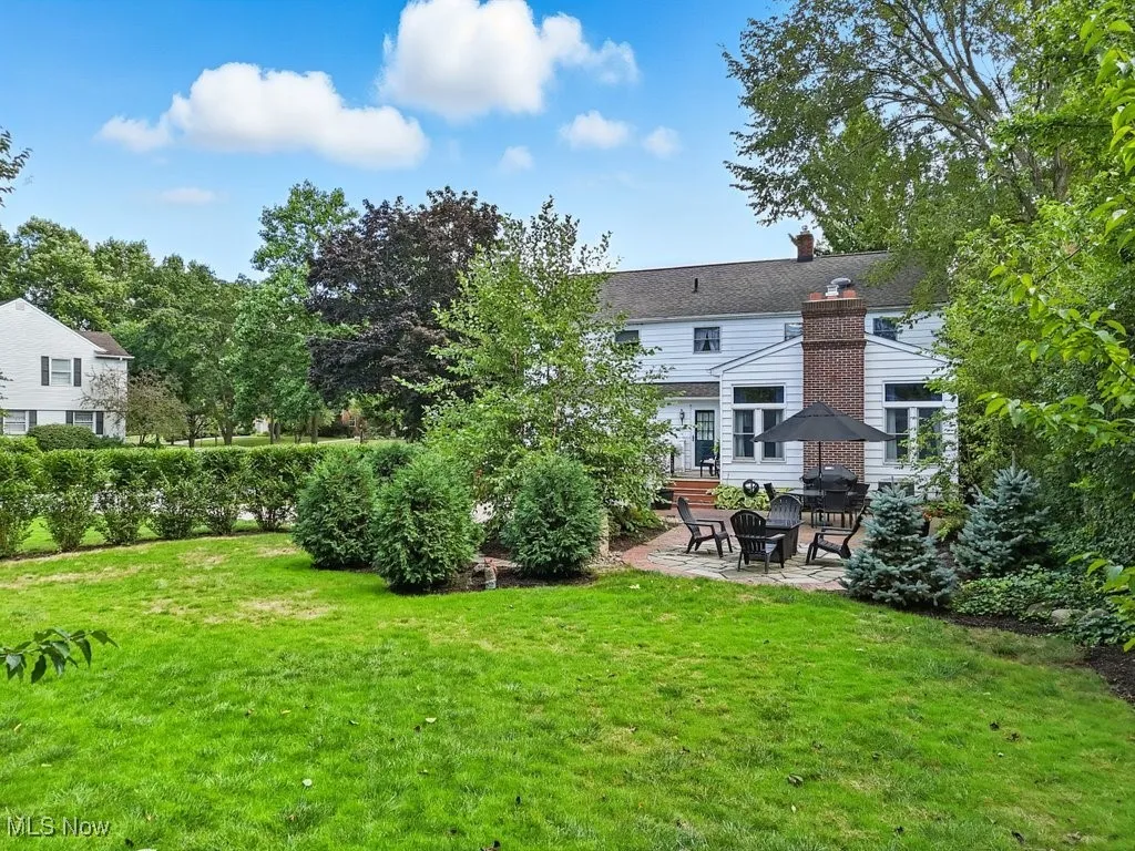 Back of property featuring a patio, a yard, and a chimney