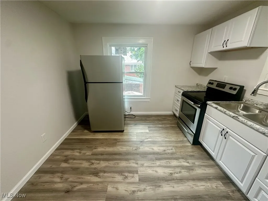 Kitchen featuring white cabinetry, stainless steel appliances, light wood-style floors, and light countertops