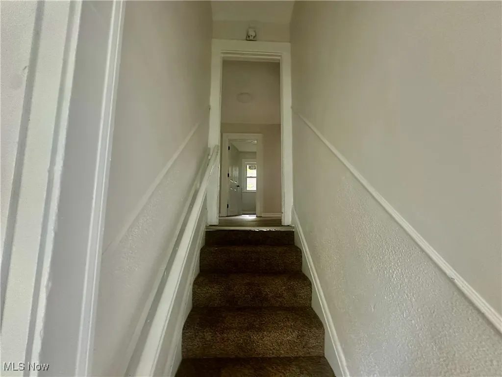 Stairway featuring a textured wall