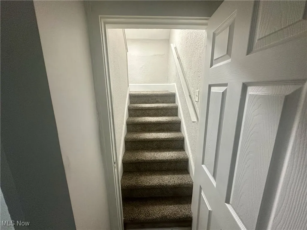 Stairs featuring a textured wall