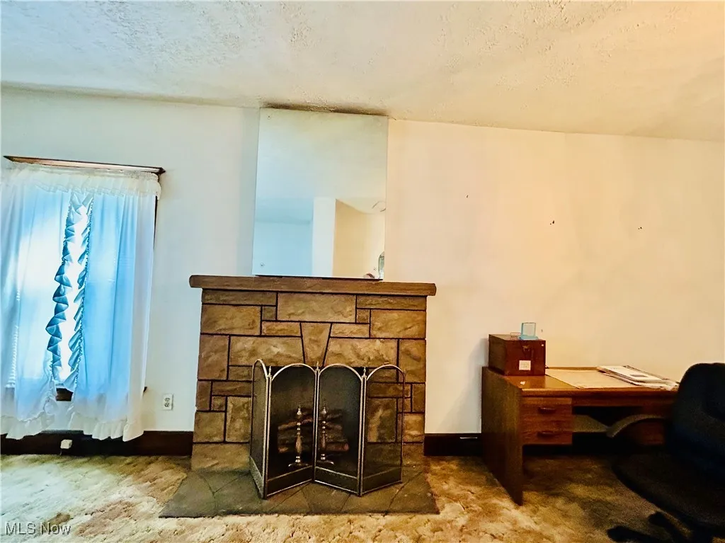 Unfurnished room featuring a textured ceiling, a chandelier, light carpet, and stairs