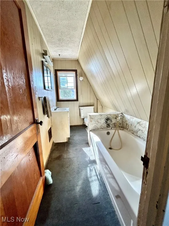 Second Floor Full bath with wood walls, vanity, a bath, vaulted ceiling, and crown molding