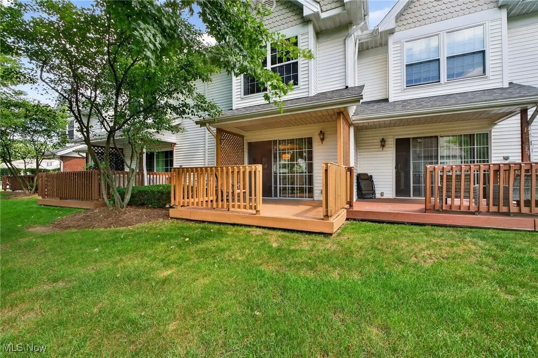 Back of property with a yard and a deck