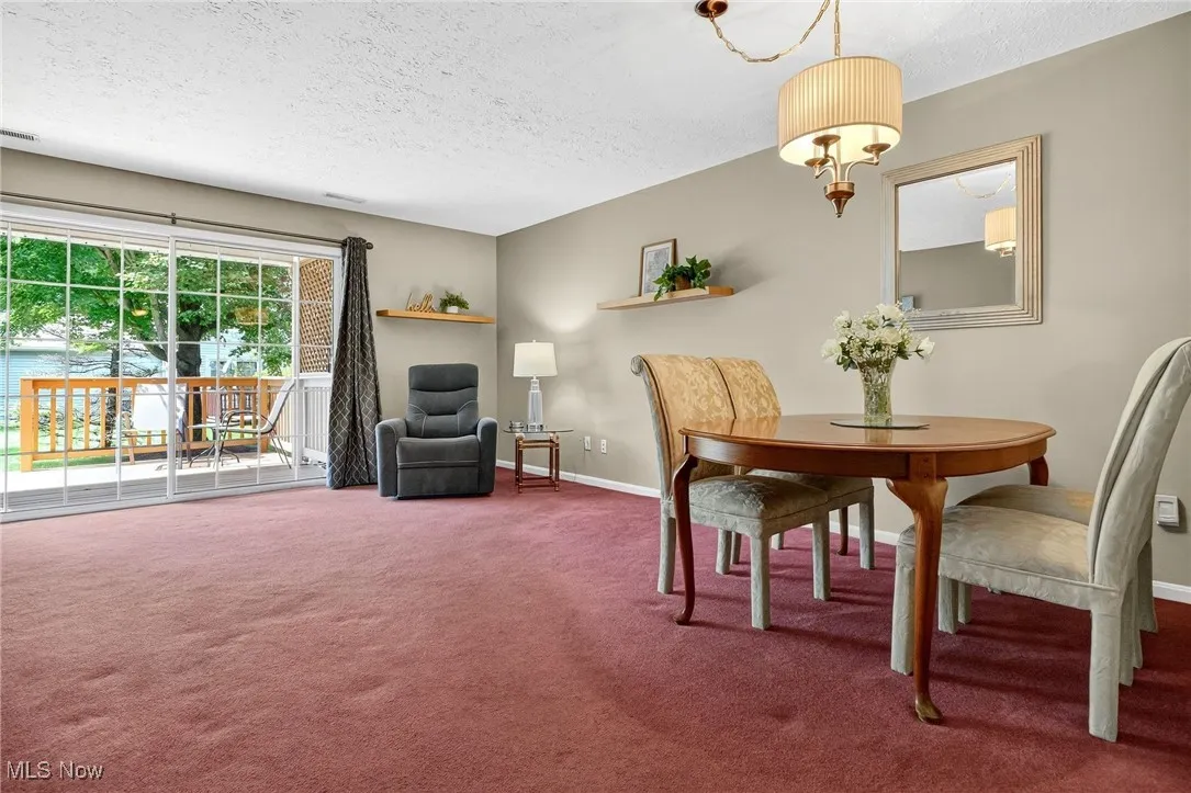 Carpeted dining space with a textured ceiling and baseboards
