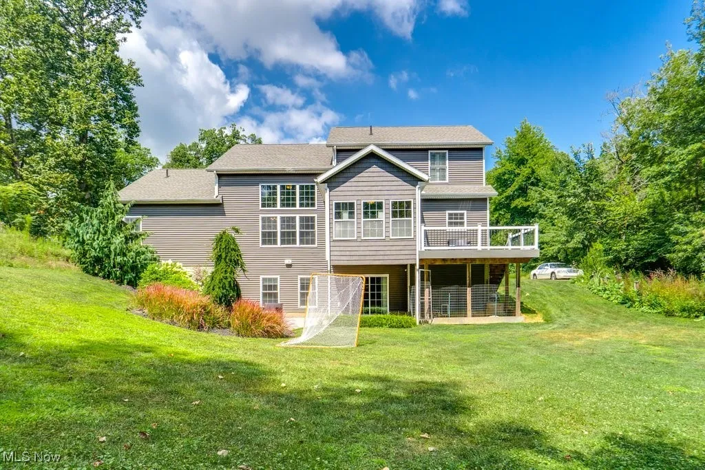 Back of house with a yard and a wooden deck