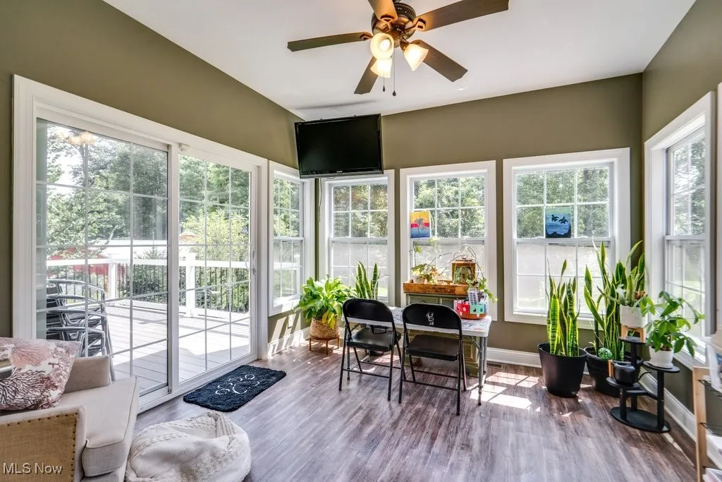 Sunroom / solarium with wood finished floors and baseboards