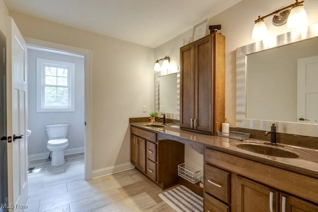 Full bath with double vanity and toilet