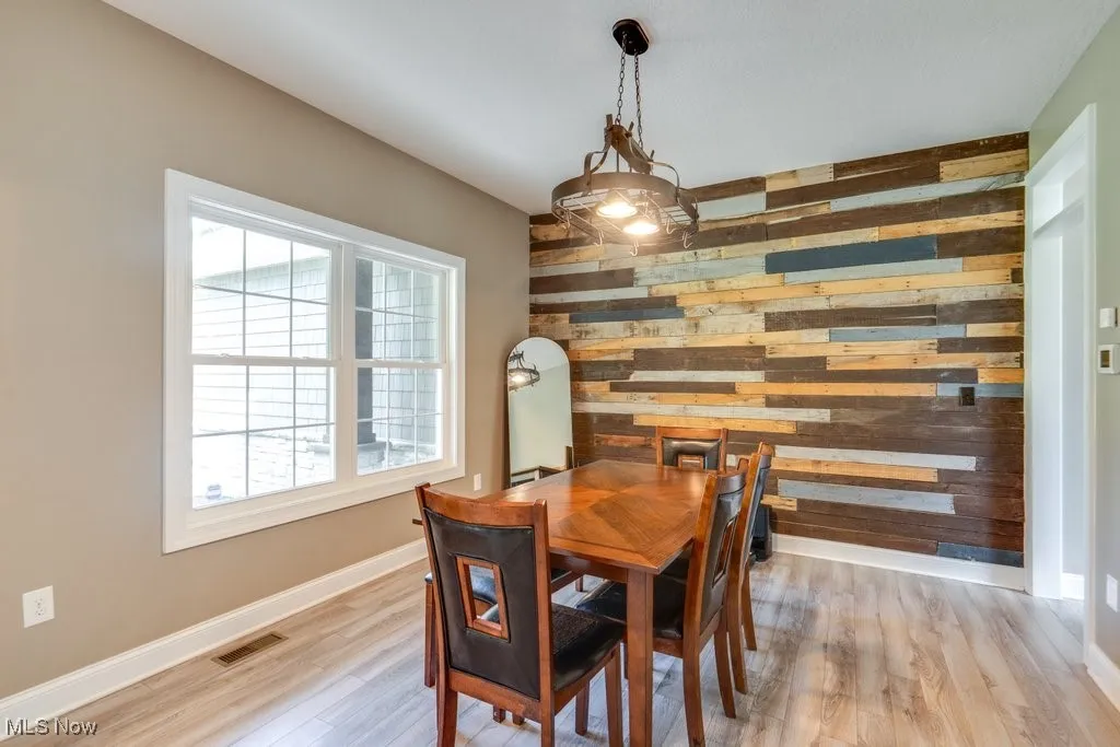 Dining area featuring wood walls and light wood-type flooring