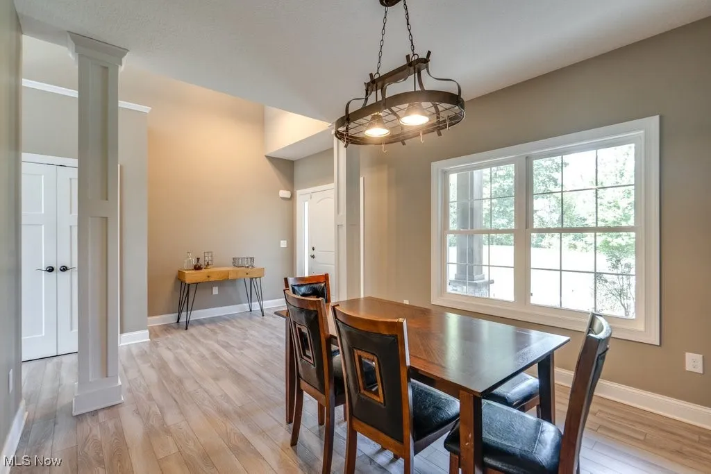Dining room with light wood finished floors and decorative columns
