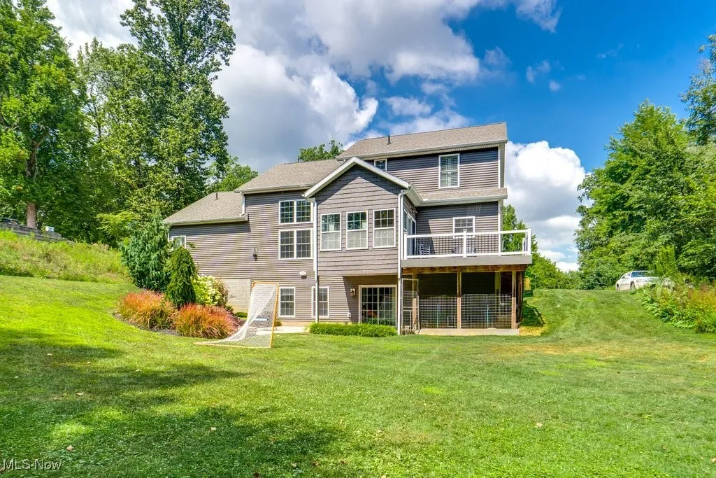 Back of property with a yard, a patio, and a deck