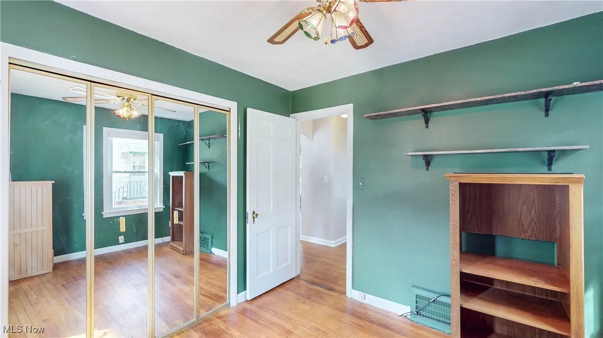 Unfurnished bedroom featuring hardwood finished floors, a closet, and ceiling fan